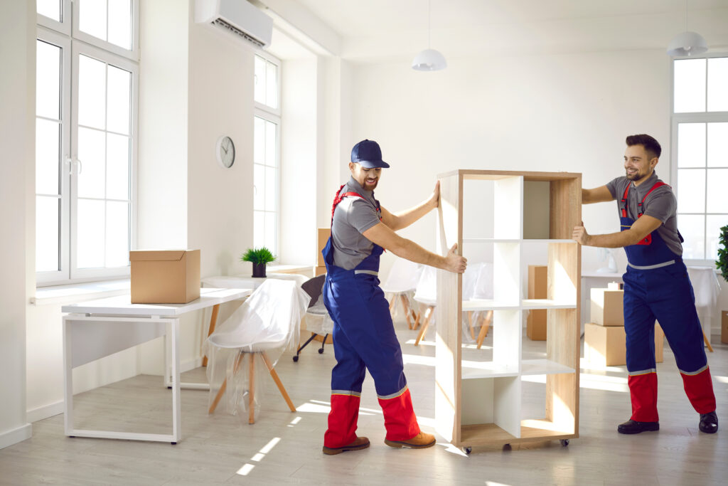Zwei Monteure montieren und stellen moderne Büromöbel in einem hellen Büro auf – professionelle Büromöbelmontage und Umzugsservice.